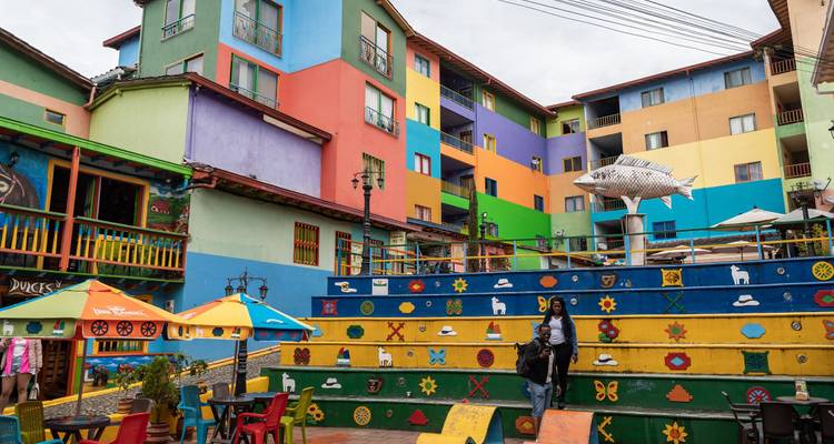 Des bâtiments aux couleurs vives et des marches décoratives animent une place colorée dans une petite ville.