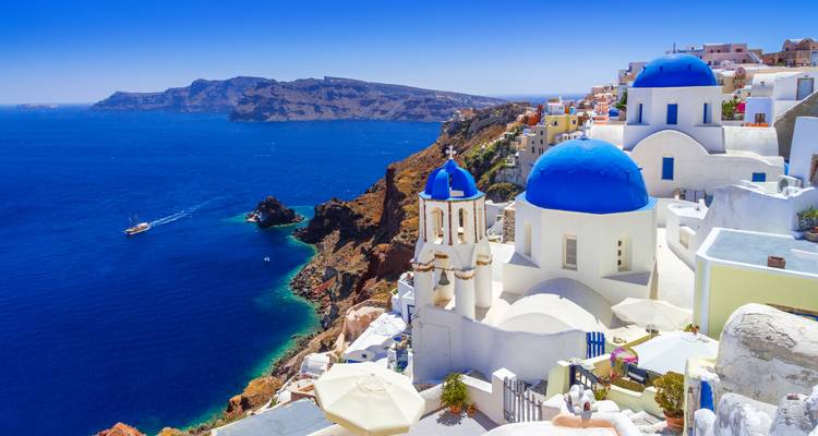 Des dômes bleus et des églises blanches perchés sur les falaises de Santorin au-dessus des eaux bleues profondes de la caldeira