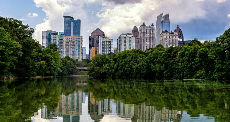 Atlanta skyline weerspiegeld in een kalm meer omringd door weelderig groen in Piedmont Park.