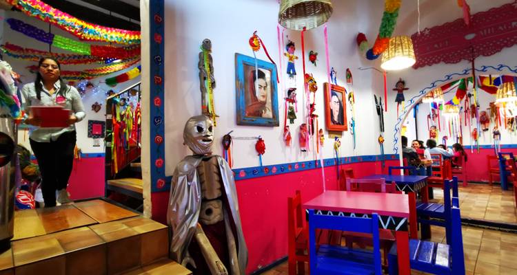 Interior vibrante de restaurante mexicano con temática folclórica con papel picado brillante, muebles llamativos y comensales disfrutando de sus comidas.