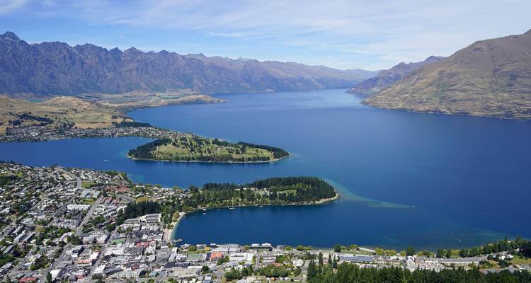 Hoher Aussichtspunkt über Queenstown mit Blick auf Lake Wakatipu, bewaldete Halbinsel, Stadt und umliegende Bergketten.