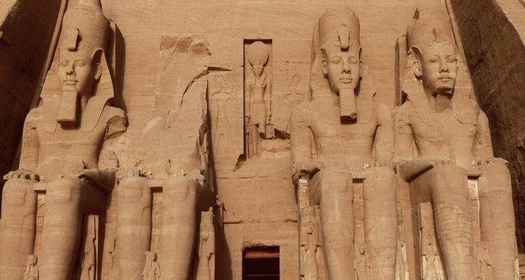 Massive sitzende Statuen von Ramses II., die in die Sandsteinfassade des Großen Tempels von Abu Simbel gemeißelt sind.