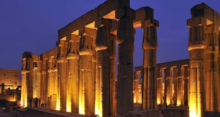 Beleuchtete Säulen des Luxor-Tempels, die gegen den tiefblauen Nachthimmel leuchten.