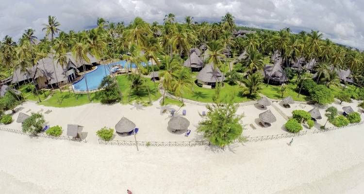 Luftaufnahme eines Strandresorts mit Pool, Palmen und strohgedeckten Bungalows neben weißem Sand