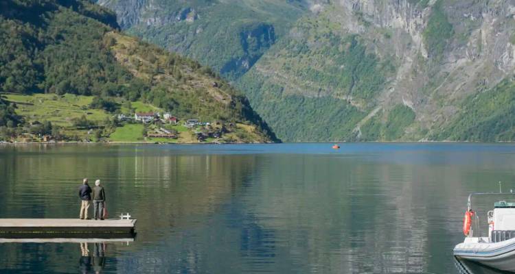 Ruhiger Geirangerfjord mit spiegelglattem Wasser, das steile grüne Berge reflektiert