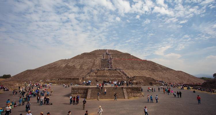 Die massive Sonnenpyramide von Teotihuacán voller Besucher, die ihre breiten Steinstufen hinaufsteigen.