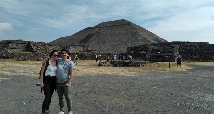 Paar posiert an archäologischer Stätte mit der Sonnenpyramide im Hintergrund.