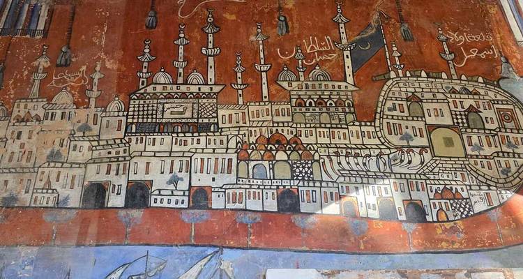 Colorful historic mural depicting a stylized city with minarets and Arabic script.