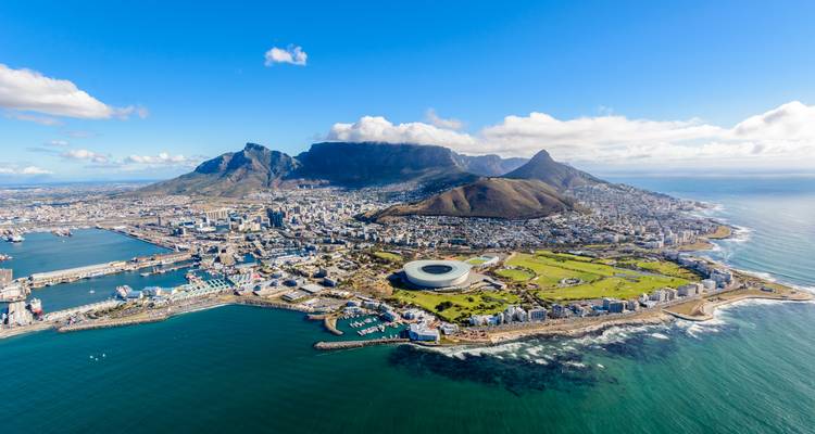 Luchtpanorama van Kaapstad met Tafelberg, stadsbekken en stadion omringd door diepblauwe oceaanwateren.