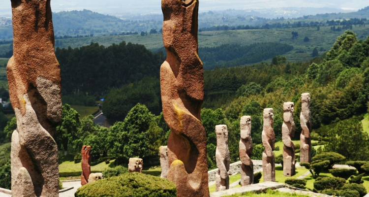 Nahaufnahme einer gedrehten Steinsäule mit Blick auf grüne Täler und bewaldete Hügel.
