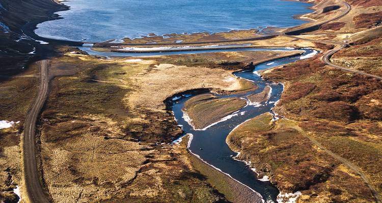 Vue aérienne des méandres de cours d'eau s'écoulant dans un lac de montagne dans les hautes terres d'Islande