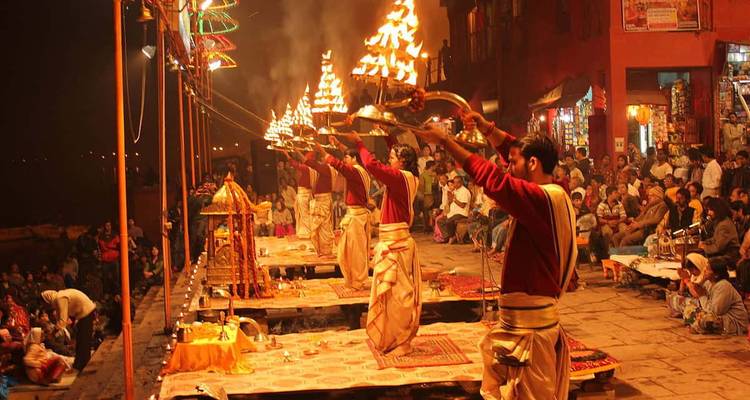 Ceremonia nocturna de Ganga Aarti con sacerdotes sosteniendo lámparas de aceite encendidas ante una multitud congregada