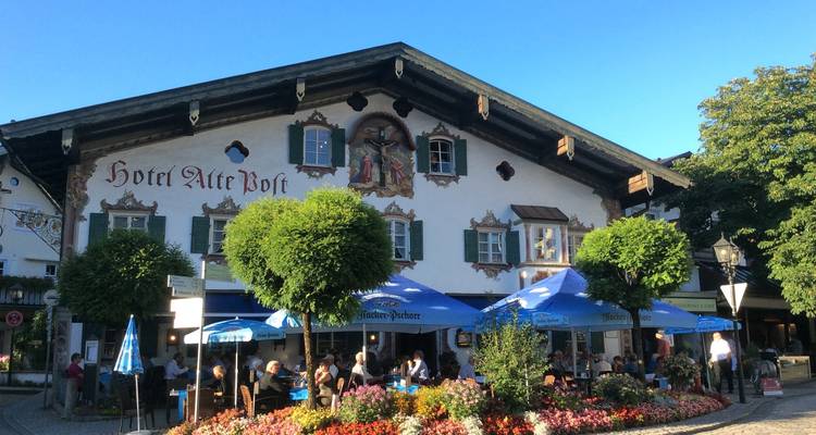 Auberge bavaroise traditionnelle Hotel Alte Post avec façade ornée de fresques et jardin à bière en plein air.