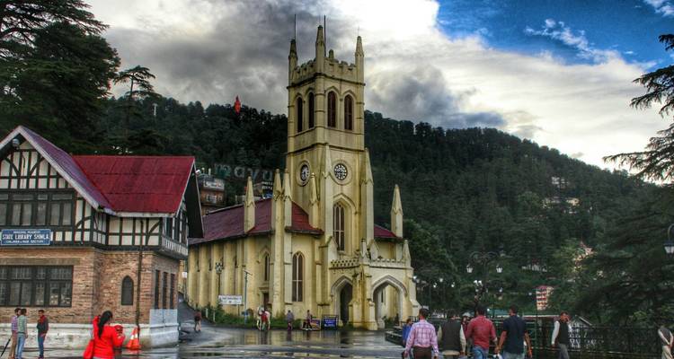 Historische Christuskirche vor bewaldeten Hügeln und dramatischen Wolken auf dem Stadtplatz von Shimla