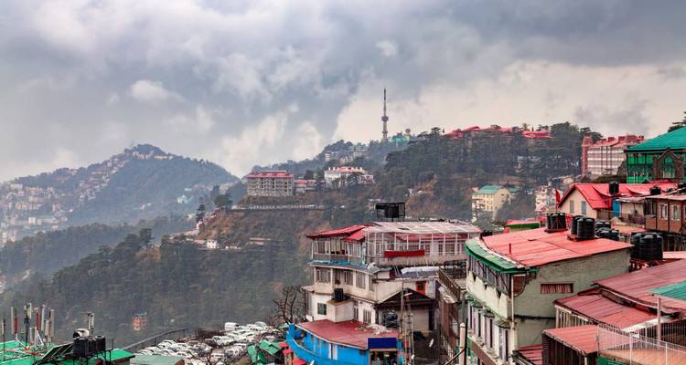 Hanglage-Stadtbild von Shimla mit bunten Dächern unter stimmungsvoller Wolkendecke