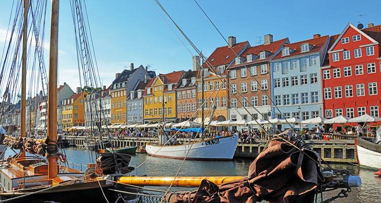 Farbenfrohe Giebelhäuser und geschäftige Außencafés säumen den Nyhavn-Kanal in Kopenhagen.