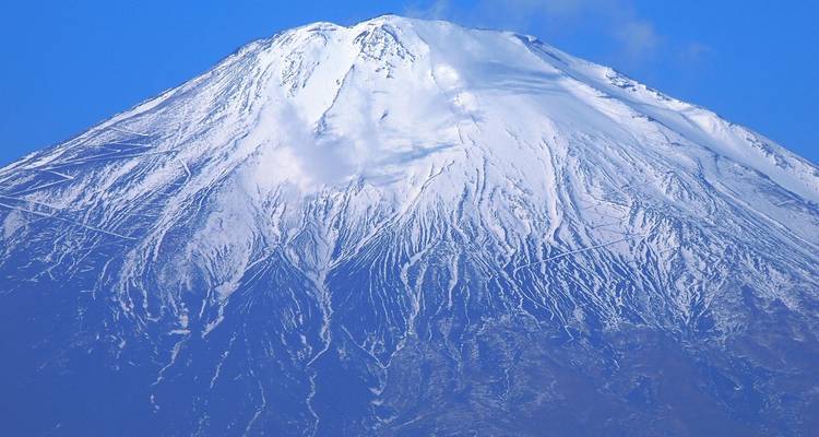 Close-up van Kilimanjaro's met sneeuw gestreepte top tegen een levendige blauwe hemel