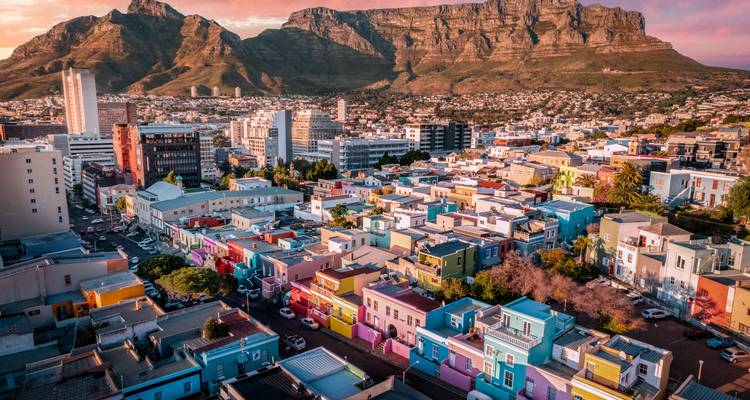 Maisons colorées de Bo-Kaap avec la Montagne de la Table qui se dresse derrière au coucher du soleil.