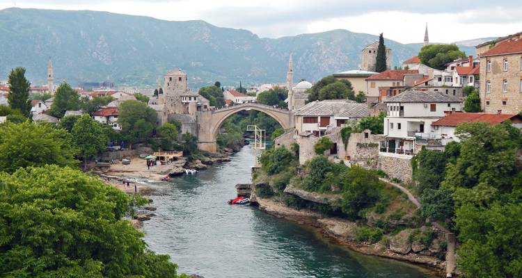 Stari Most brug en stenen stad gezien op een bewolkte dag met rivier die eronder stroomt.