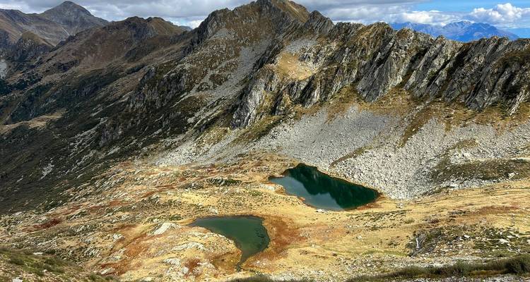 Los lagos alpinos de gran altitud brillan bajo crestas montañosas dentadas en clima despejado.