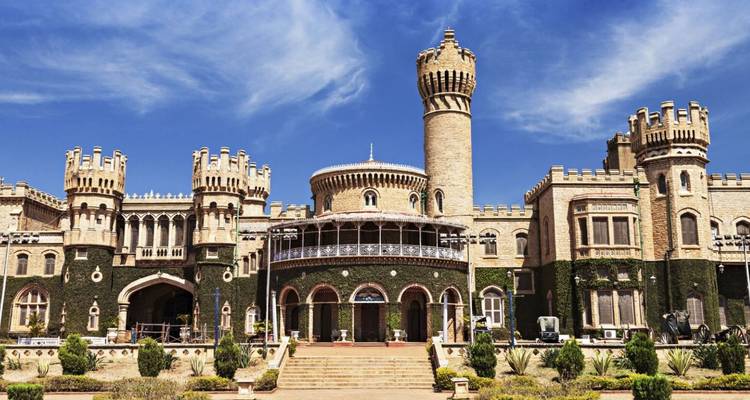 Majestätischer Bangalore-Palast mit Türmen und efeuumrankten Mauern unter einem tiefblauen Himmel.