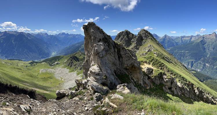 Cresta alpina panorámica con formaciones rocosas dentadas y cordilleras distantes