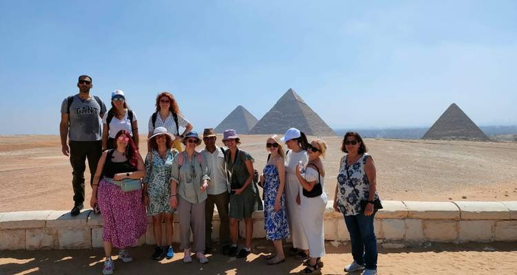Reisegruppe posiert vor den Pyramiden an einem klaren Wüstentag.