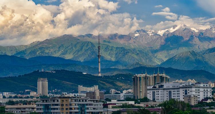 Panorama urbain d'Almaty avec la tour de télévision Kok Tobe et les montagnes enneigées du Tien Shan en arrière-plan.