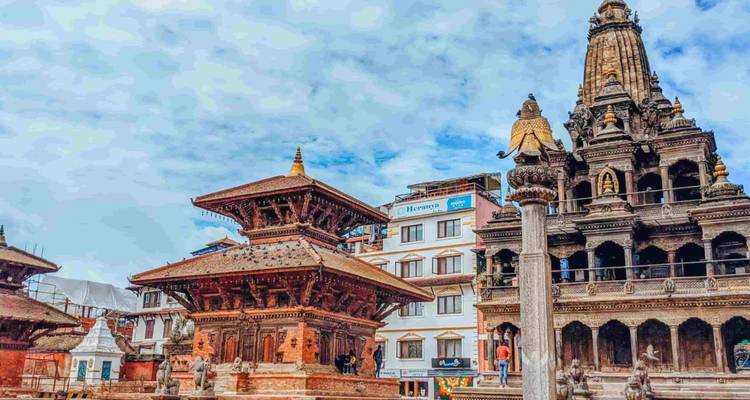 Historische Patan-Tempel mit gestuften Dächern erheben sich gegen einen teilweise bewölkten Himmel im Kathmandu-Tal.