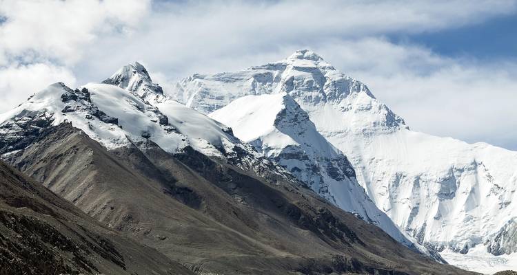 Des sommets himalayens enneigés s'élèvent abruptement sous un ciel bleu cristallin.