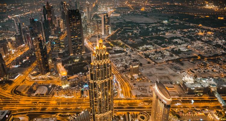 Vue aérienne nocturne spectaculaire des autoroutes illuminées et des gratte-ciel de Dubaï.