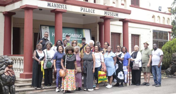 Groupe de touristes posant devant l'entrée du Musée du Palais de Manhyia à Kumasi