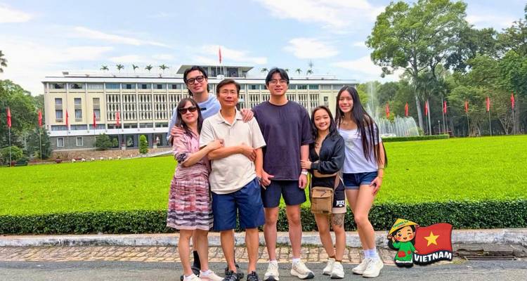 Familie die voor het Independence Palace-gazon staat met Vietnam-sticker overlay.