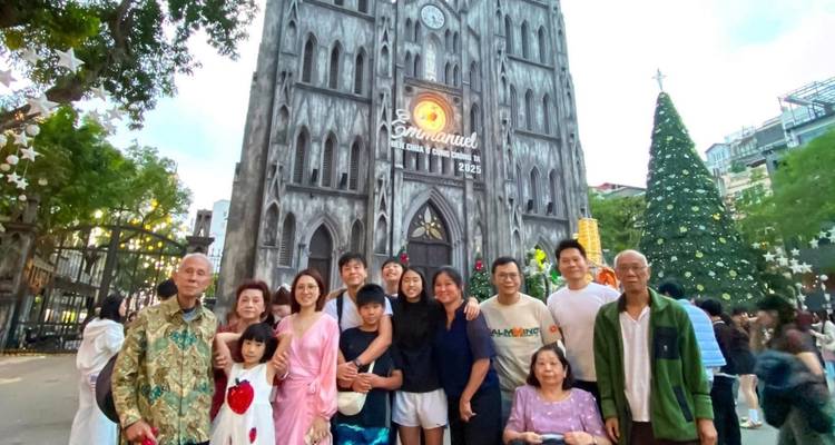 Grote familie poseert voor de Sint-Jozefskathedraal in Hanoi met een Vietnam-sticker overlay.