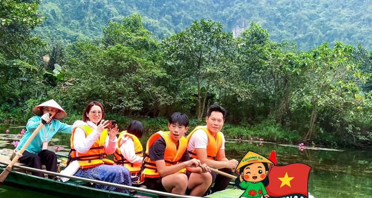 Mensen met zwemvesten in een roeiboot op een weelderige rivier met een Vietnam-sticker eroverheen.