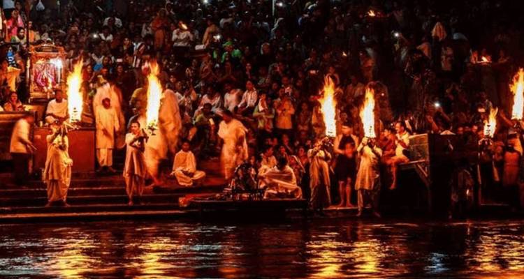 Nightly Ganga Aarti ceremony with priests holding blazing torches by the river steps.