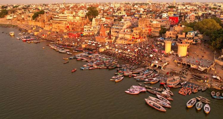 Sunset aerial of Varanasi’s riverfront crowded with boats and pilgrims.