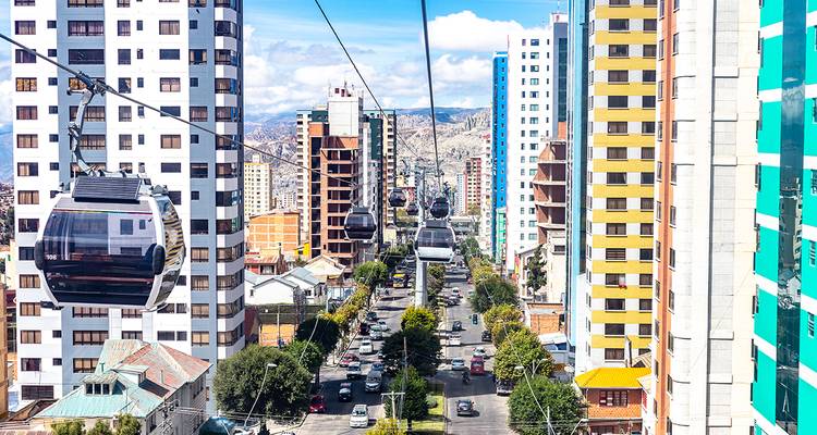 Urbane Allee, gesehen von einer Luftseilbahn aus, die von hohen modernen Gebaeuden in einer hochgelegenen Stadt flaniert wird.
