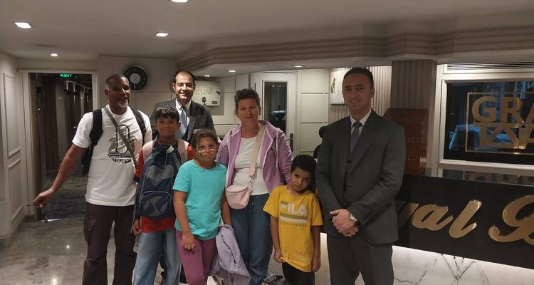 Familie mit Führern und Hotelpersonal, die sich in einer Marmor-Hotellobby in Ägypten fotografieren lassen.