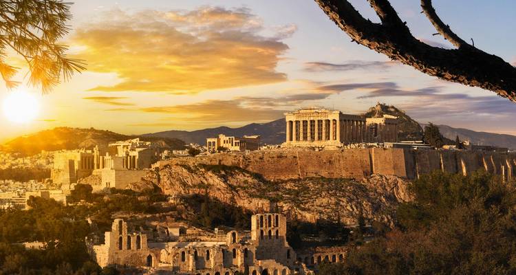 Un coucher de soleil doré illumine l'Acropole et les ruines antiques d'Athènes depuis un point de vue panoramique.