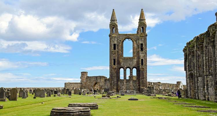 Tour en ruines et pierres tombales de la Cathédrale de St Andrews sur un ciel bleu éclatant.