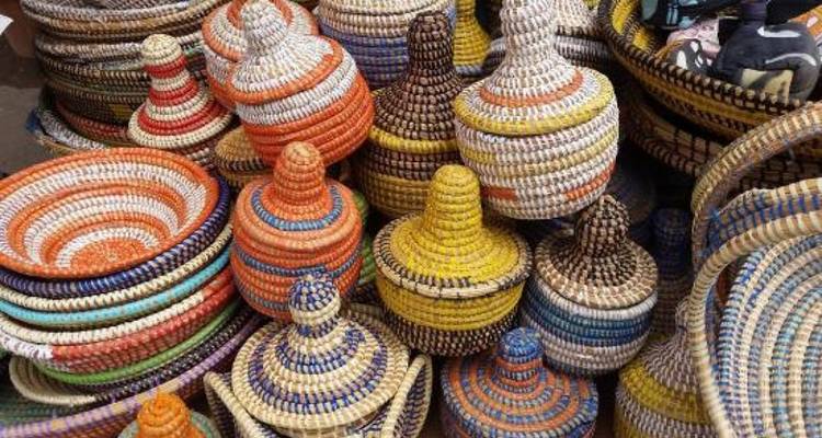Pile de paniers tissés colorés et de couvercles dans un marché d'Afrique de l'Ouest