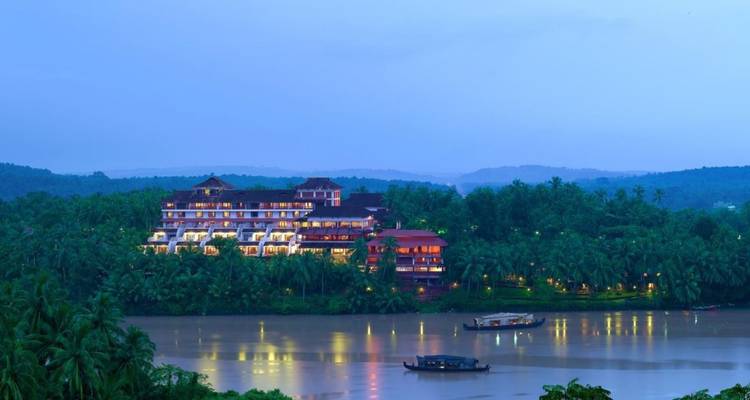 Riverside-Resortanlage, die in der Dämmerung beleuchtet ist und von dichter tropischer Vegetation umgeben ist