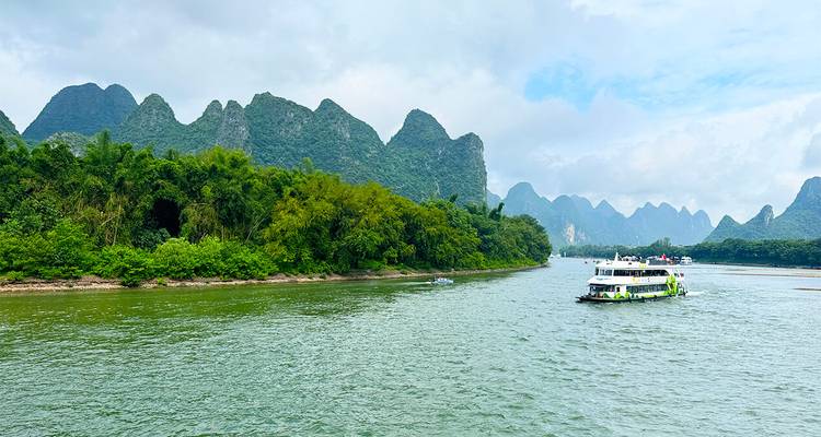 Croisière touristique en bateau le long de la rivière Li avec des pics karstiques en arrière-plan