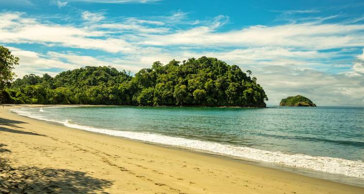 Crique sableuse immaculée avec des vagues douces et des îlots boisés à Manuel Antonio