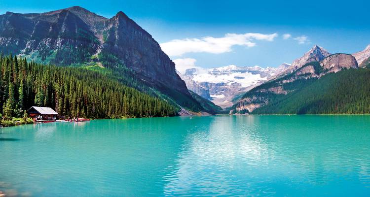 L'eau turquoise du glacier remplit un lac de montagne entouré d'une forêt de pins et de pics enneigés.