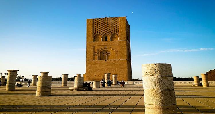 Vue diurne de la Tour Hassan et des colonnes de pierre environnantes sur une vaste esplanade.