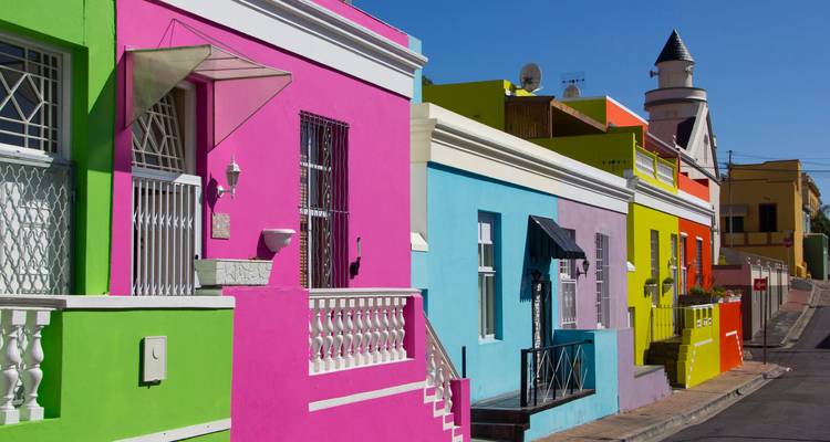 Farbenfrohe Reihenhäuser, die an einem klaren Tag eine enge Straße im Stadtteil Bo-Kaap säumen