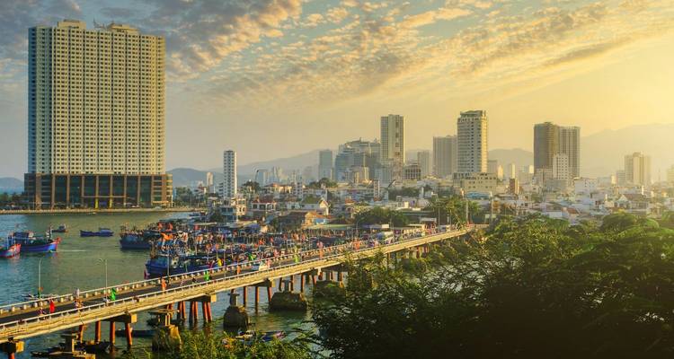 Golden light over Nha Trang harbour, city towers and fishing pier