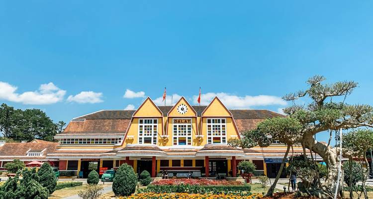 Colorful French-colonial Dalat Railway Station under a clear blue sky